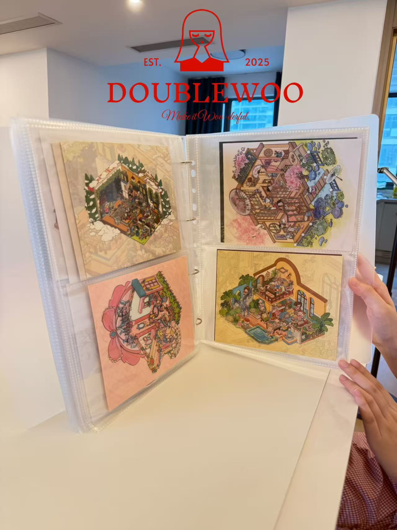 Open album with colorful illustrations held by a person, DoubleWoo logo visible.