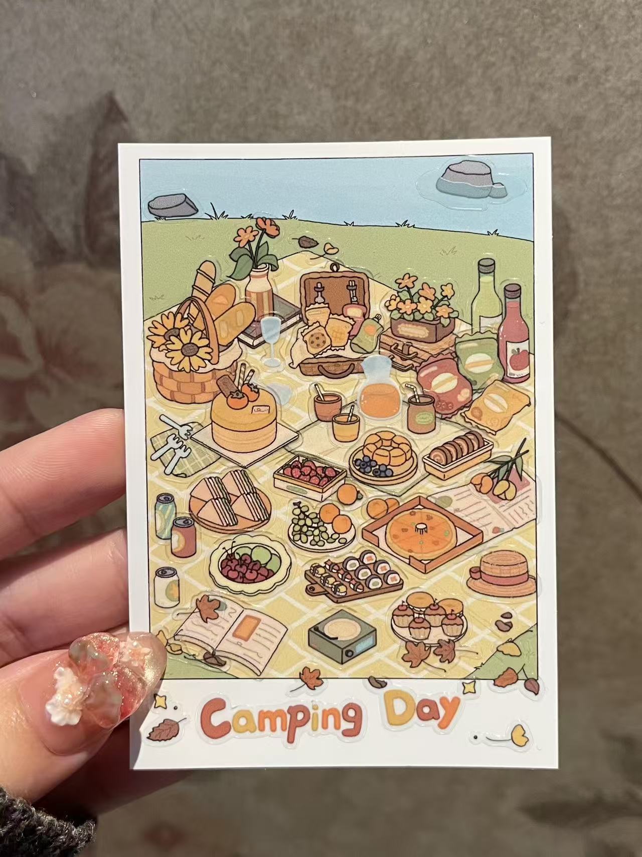 Illustrated card with a camping theme featuring food and outdoor items.