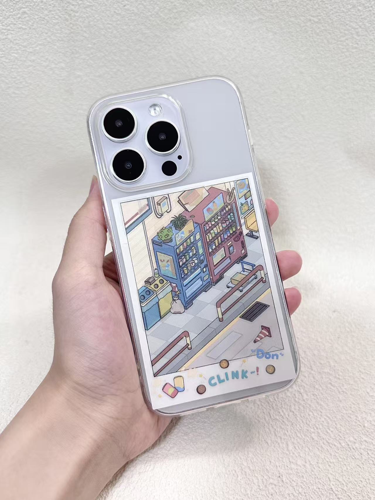 Phone case with a colorful illustration held by a hand on a light gray background