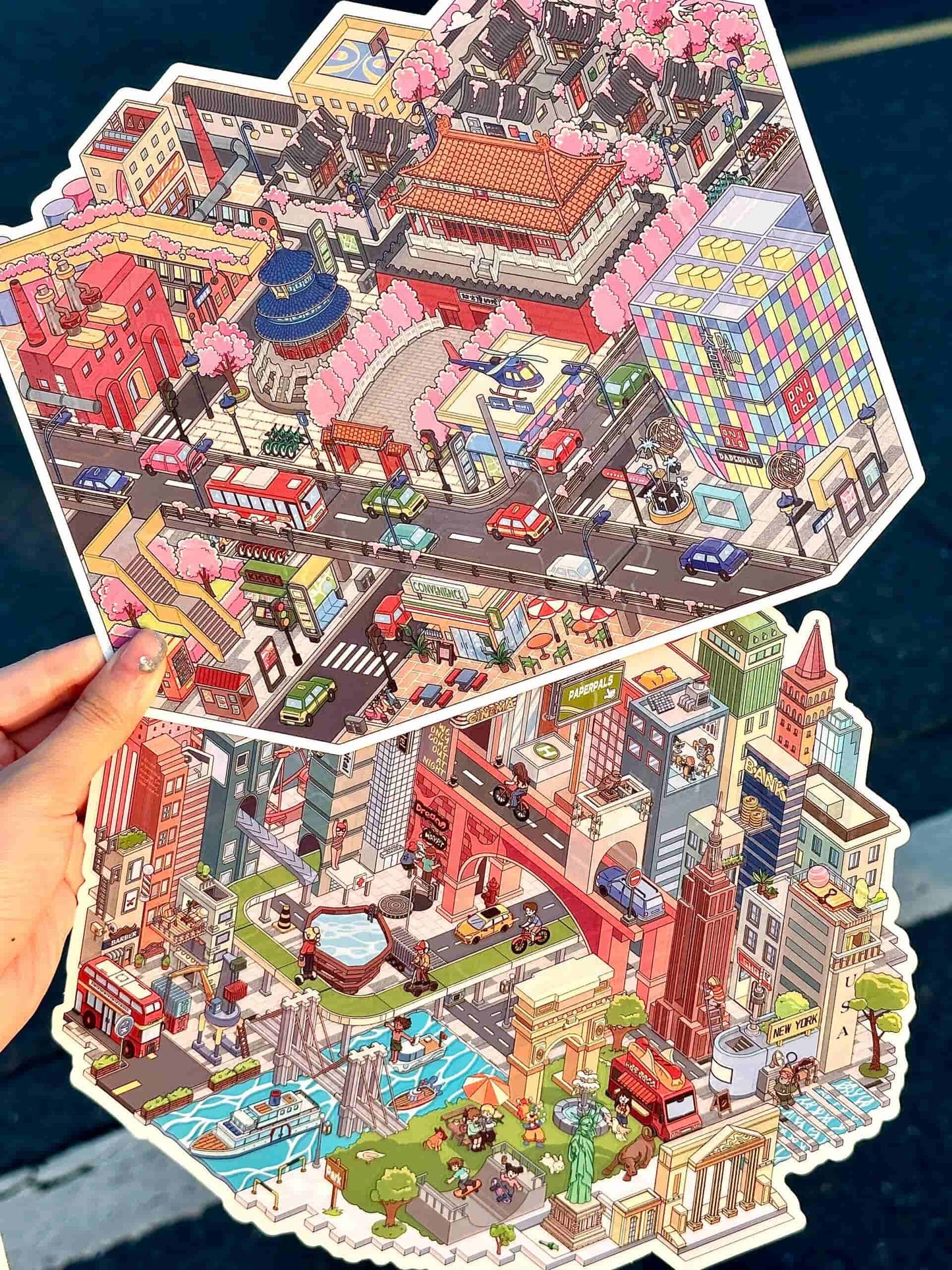 Colorful cityscape puzzle held by a hand with a blue surface in the background